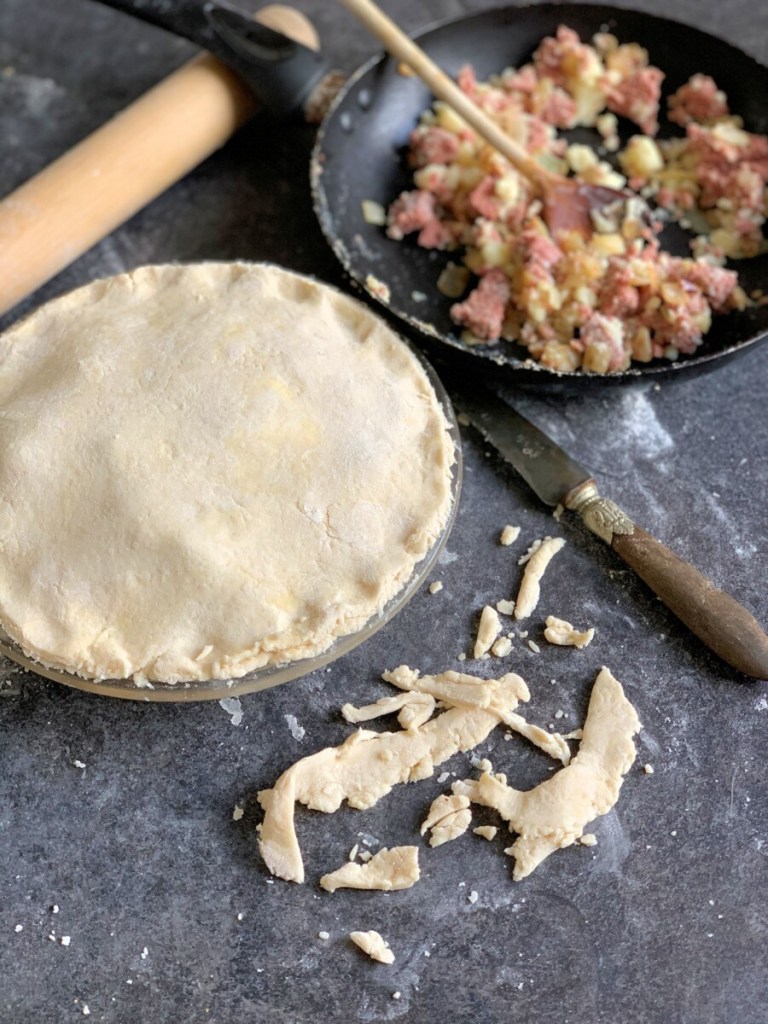 Spoon the corned beef filling into the middle of the pastry, leaving about 1”/2.5cm border around the edge. Roll out the remaining pastry and cover the filling with the pastry, sealing around the edges with your thumb, or with a knife/fork. (You can brush some beaten egg on the border before sealing)