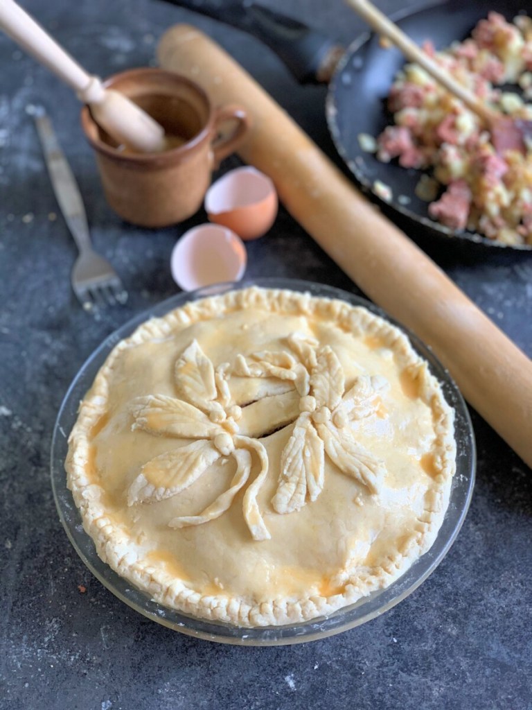 Trim the edges and brush the beaten egg all over the pie crust, make two a cuts for air holes in the top and decorate with excess pastry if desired.