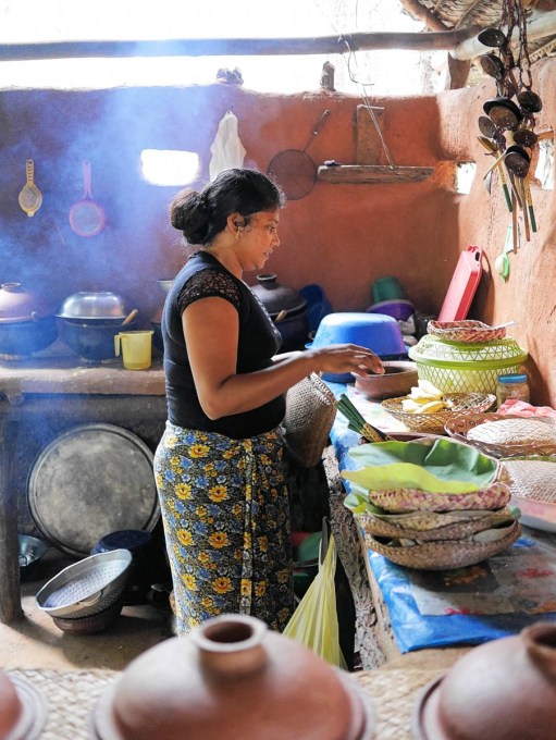 Woman cooking in traditional clay-pot jungle restaurant in Hiridunna VIllage